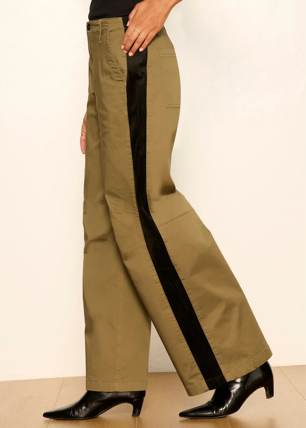 Woman wearing vintage olive pants with black boots.