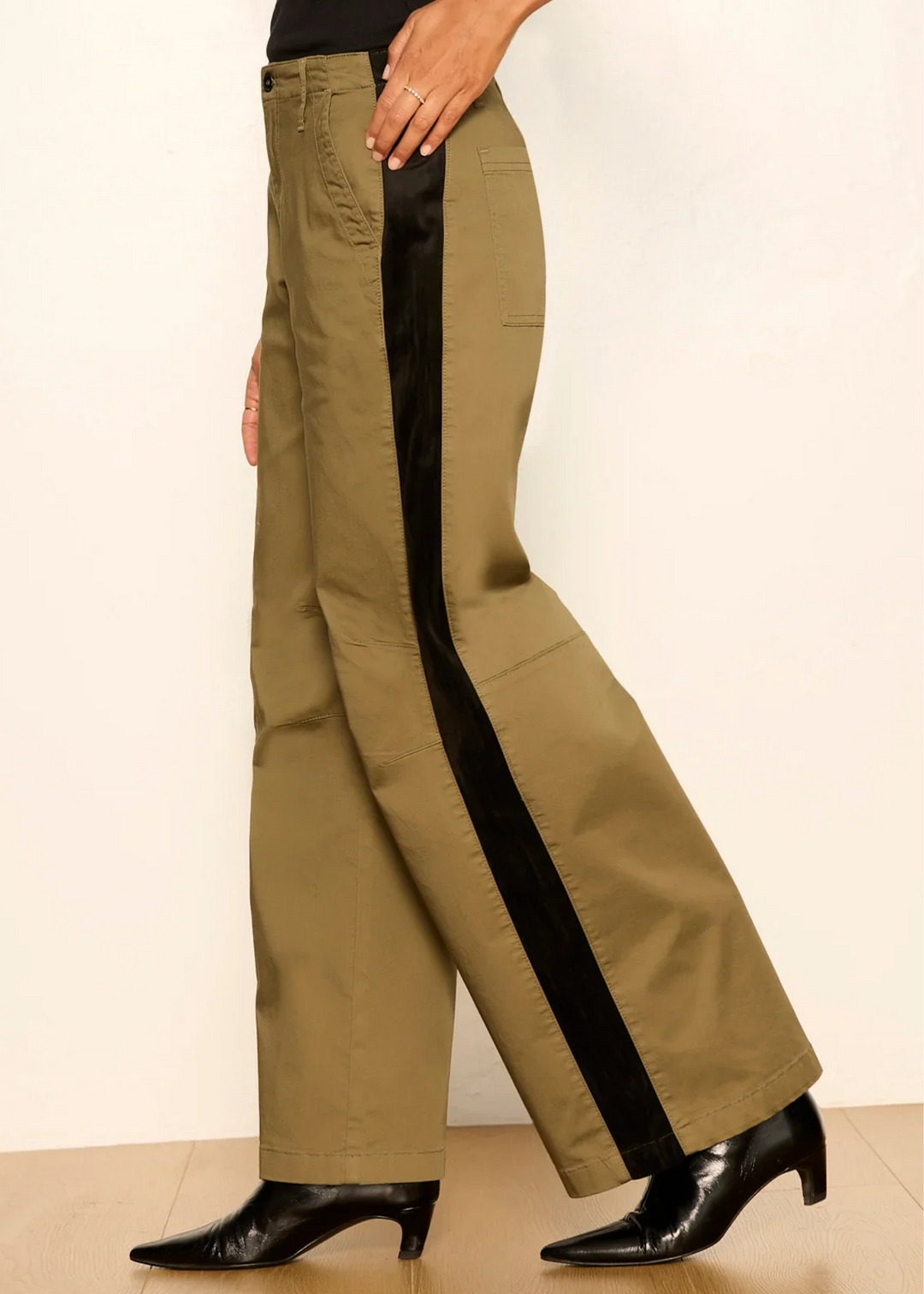 Woman wearing vintage olive pants with black boots.