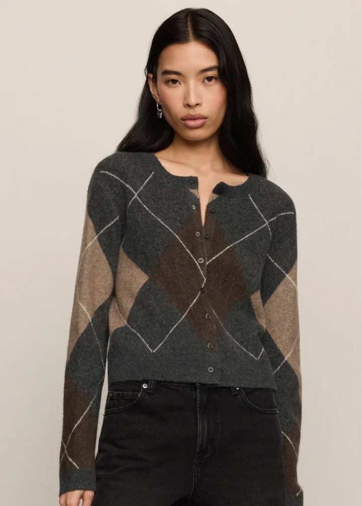 Woman wearing a grey cardigan with argyle pattern.