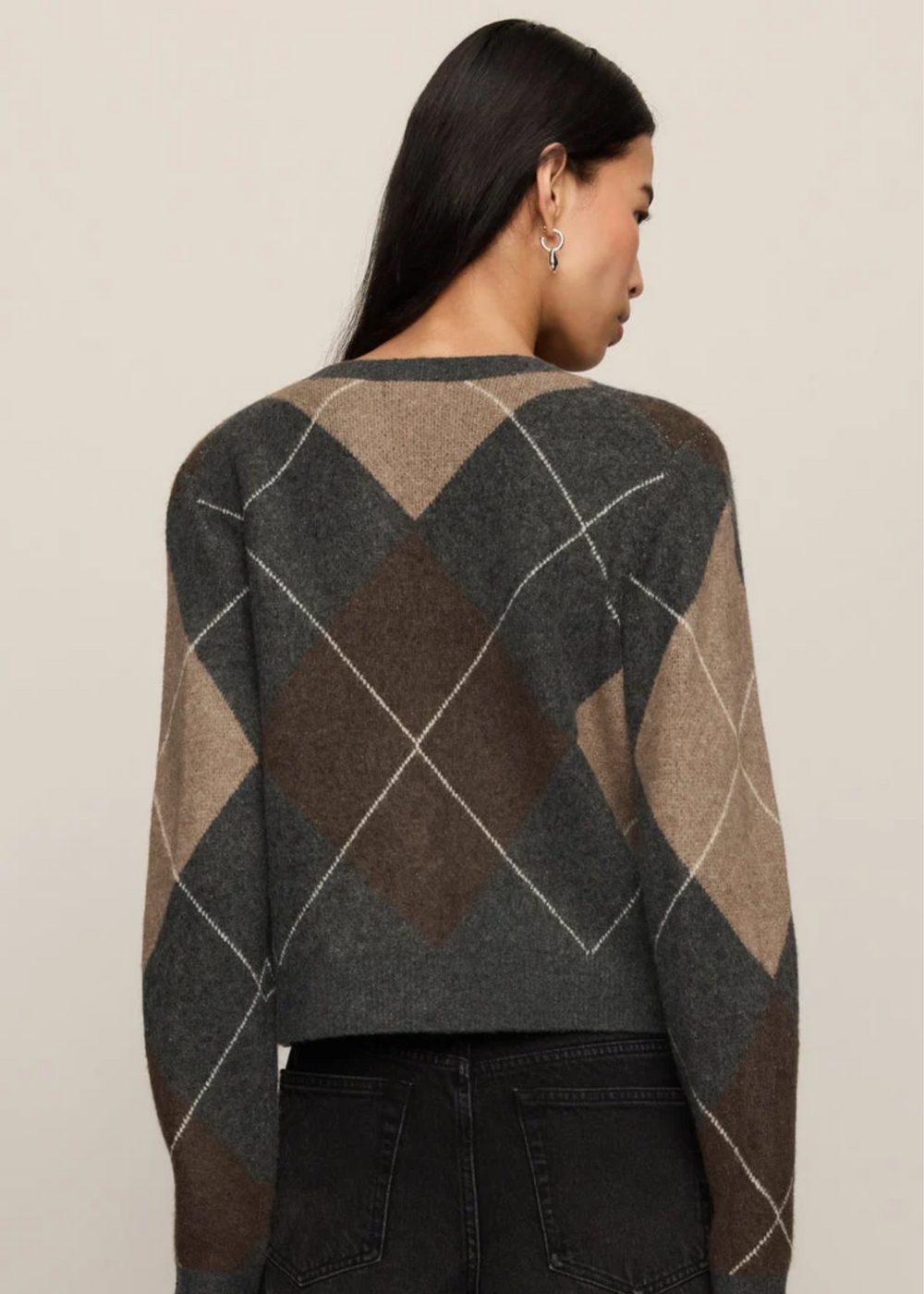 Woman wearing a grey cardigan with argyle pattern.
