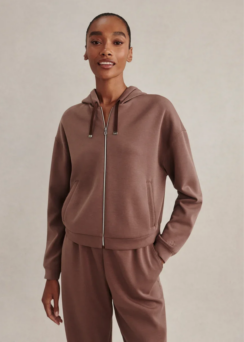 Woman wearing a coffee colored sweat set.