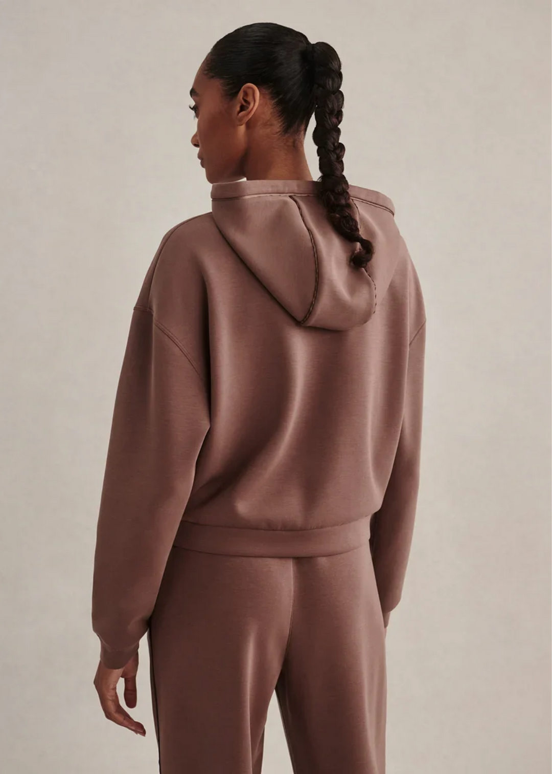 Woman wearing a coffee colored sweat set.