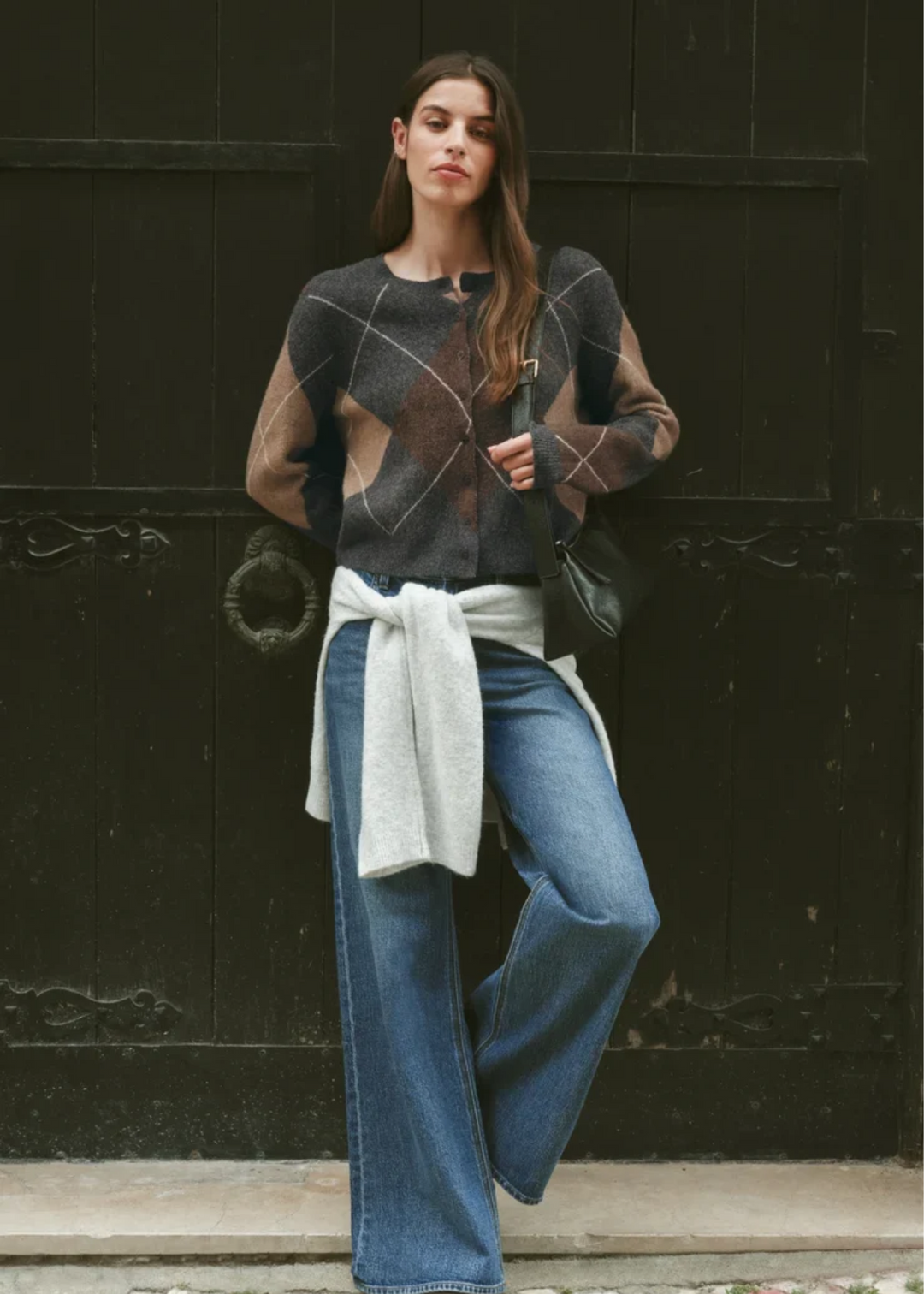 Woman wearing a grey cardigan with argyle pattern.