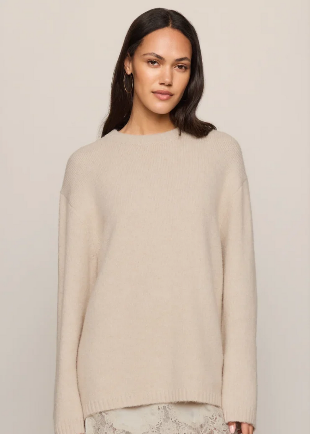 Woman wearing a frosted pearl sweater that is long sleeved.