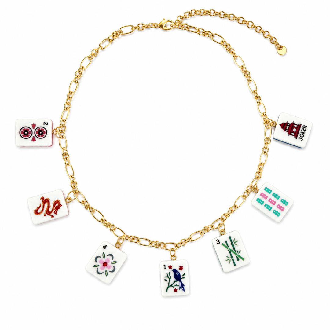 Gold chain necklace with various small square charms on a white background