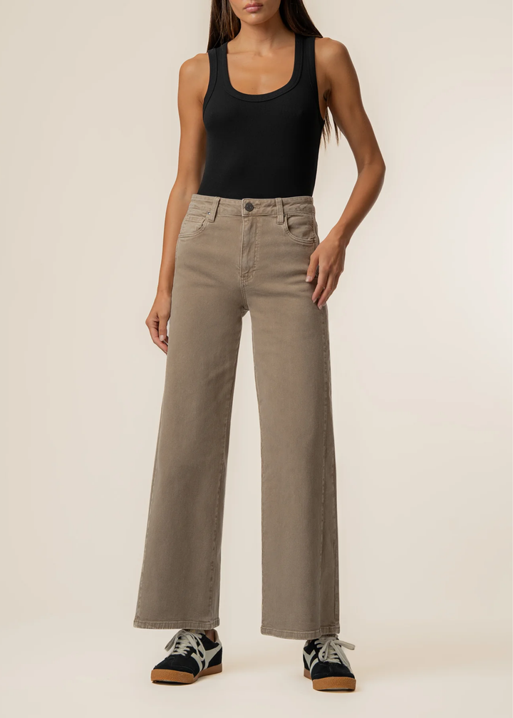 Women facing forward wearing black tank top and milk tea colored wide leg jeans.