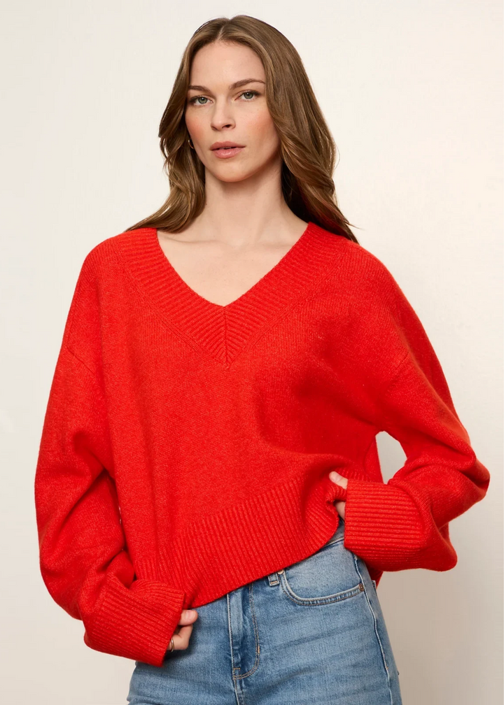 Woman wearing a red v-neck sweater.