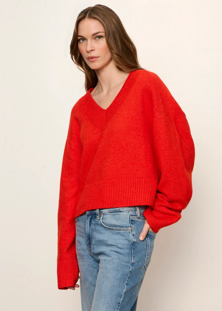 Woman wearing a red v-neck sweater.