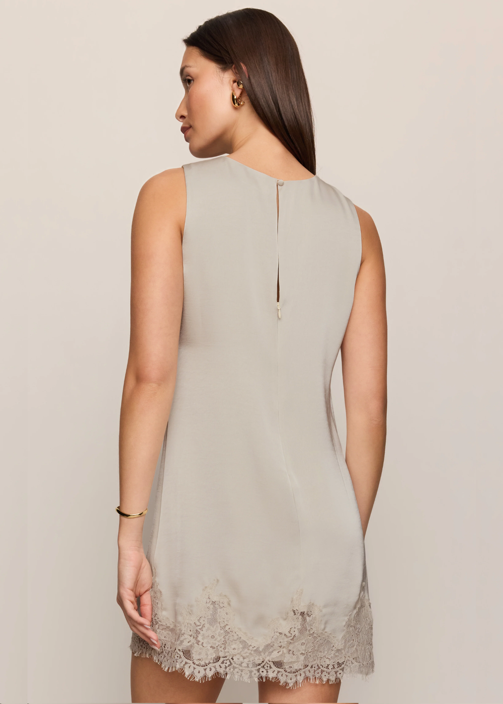 Women wearing lace mini dress that is satin, and she is turned around. 