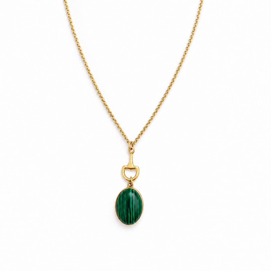 A gold chain necklace featuring an oval green malachite stone pendant with a gold bottle opener charm suspended above it, set against a plain white background.