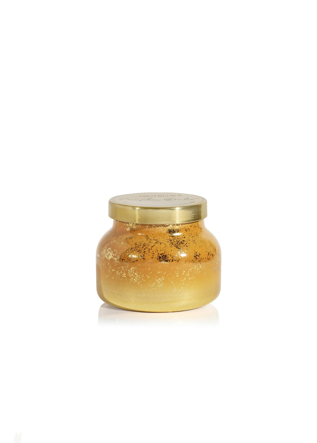 Orange and gold ombre candle with gold speck details and a gold lid on a white background