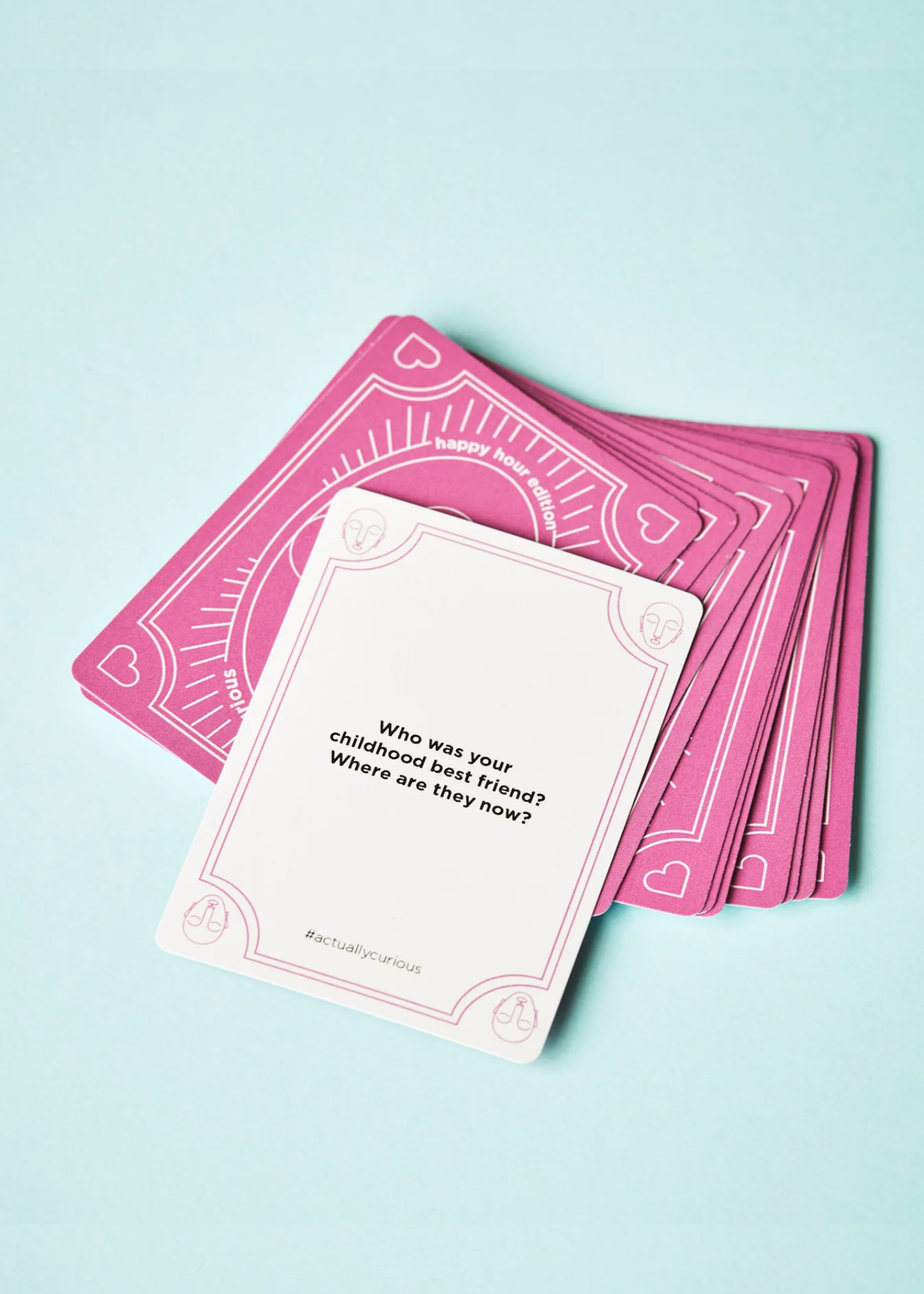 A white card with a question laying on top of pink cards