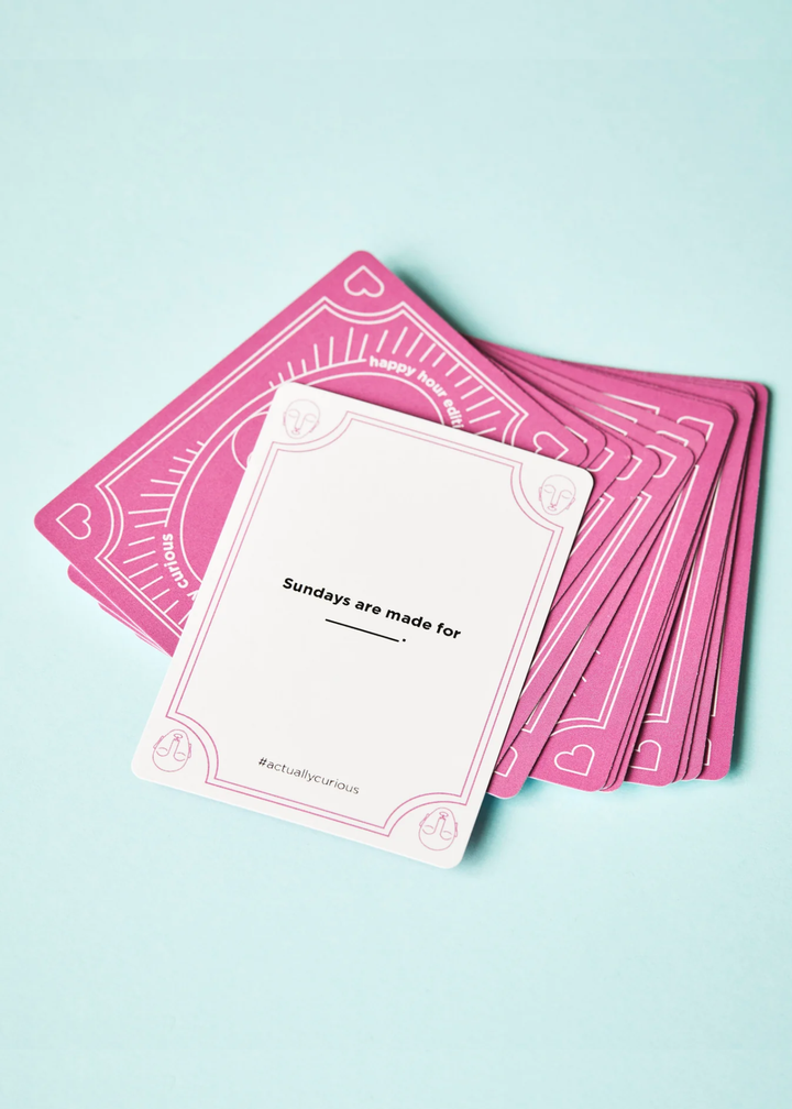 A white card with a question laying on top of pink cards