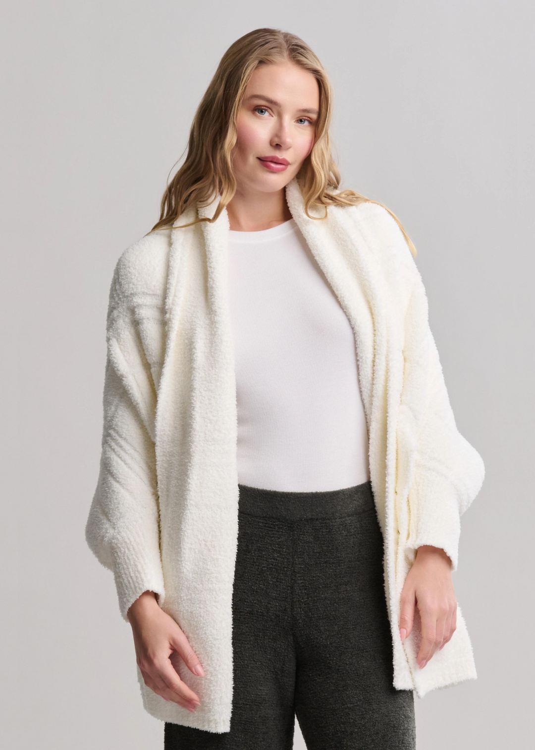 Woman wearing a pearl blanket wrap in front of a grey background