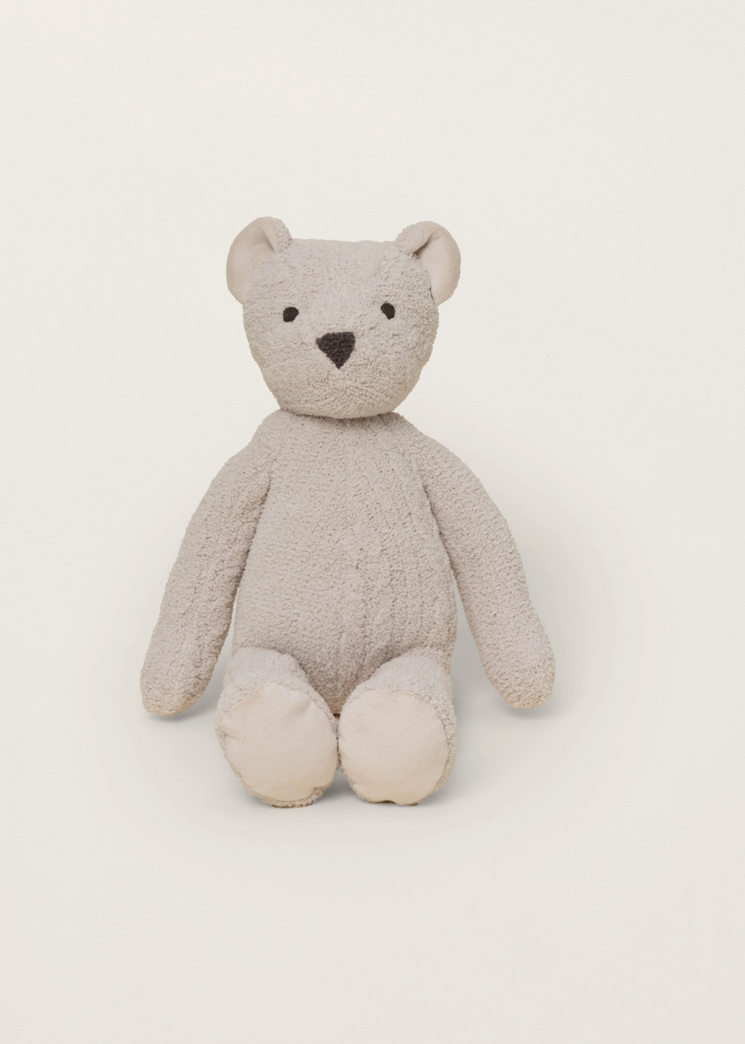Tan stuffed teddy bear sitting on a white background facing forward