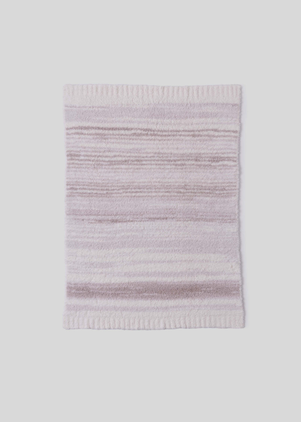 Pink and cream striped blanket laying on a white background