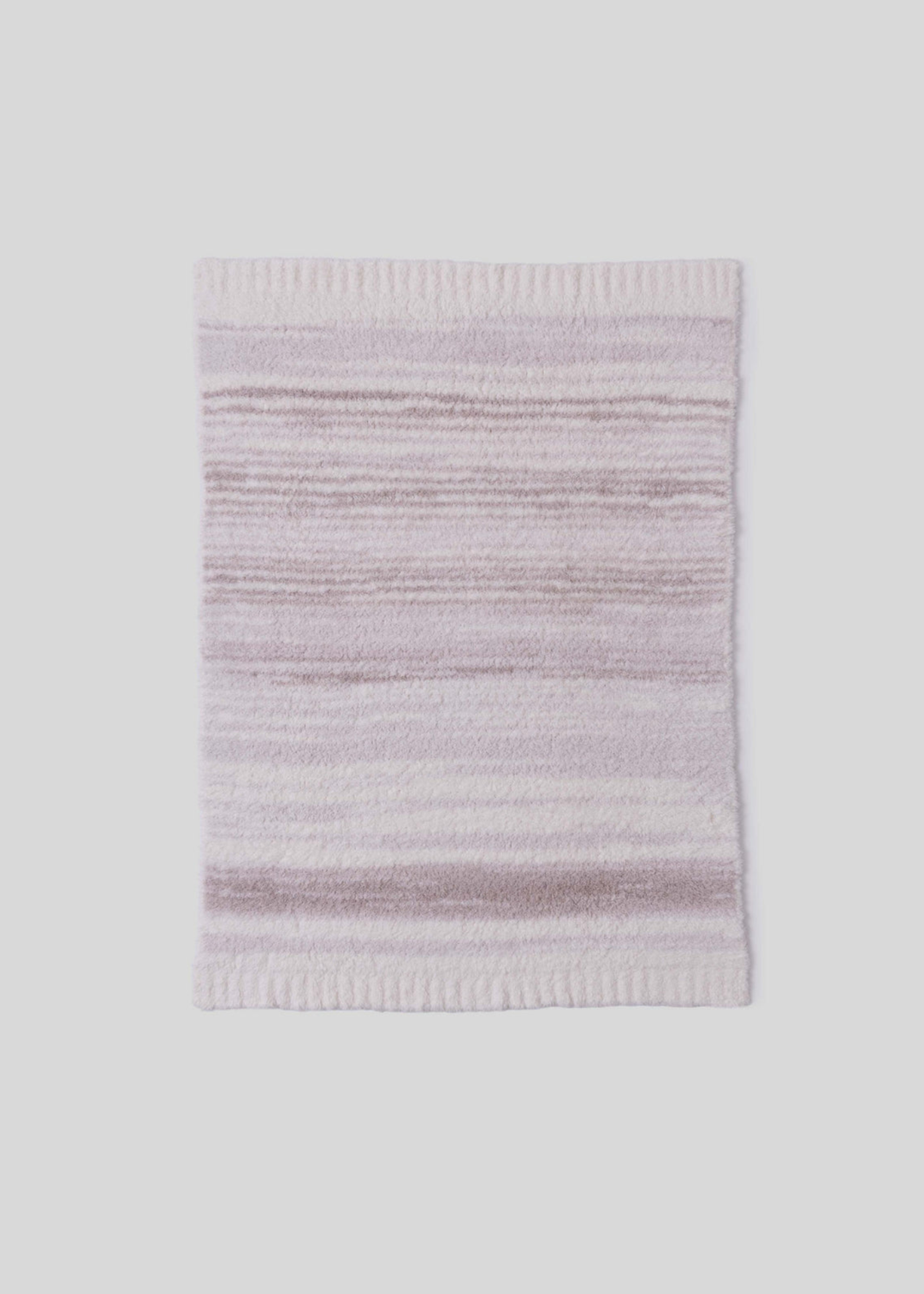 Pink and cream striped blanket laying on a white background