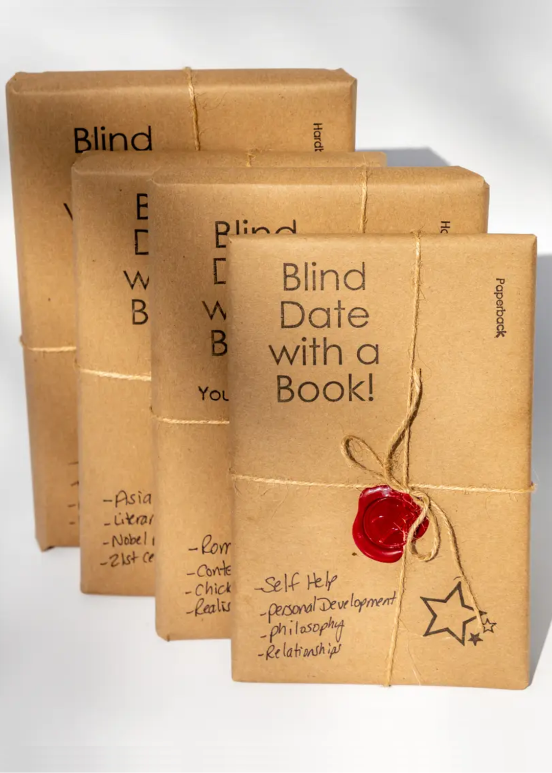 Book wrapped in brown paper with a bakers twine bow and a red wax seal