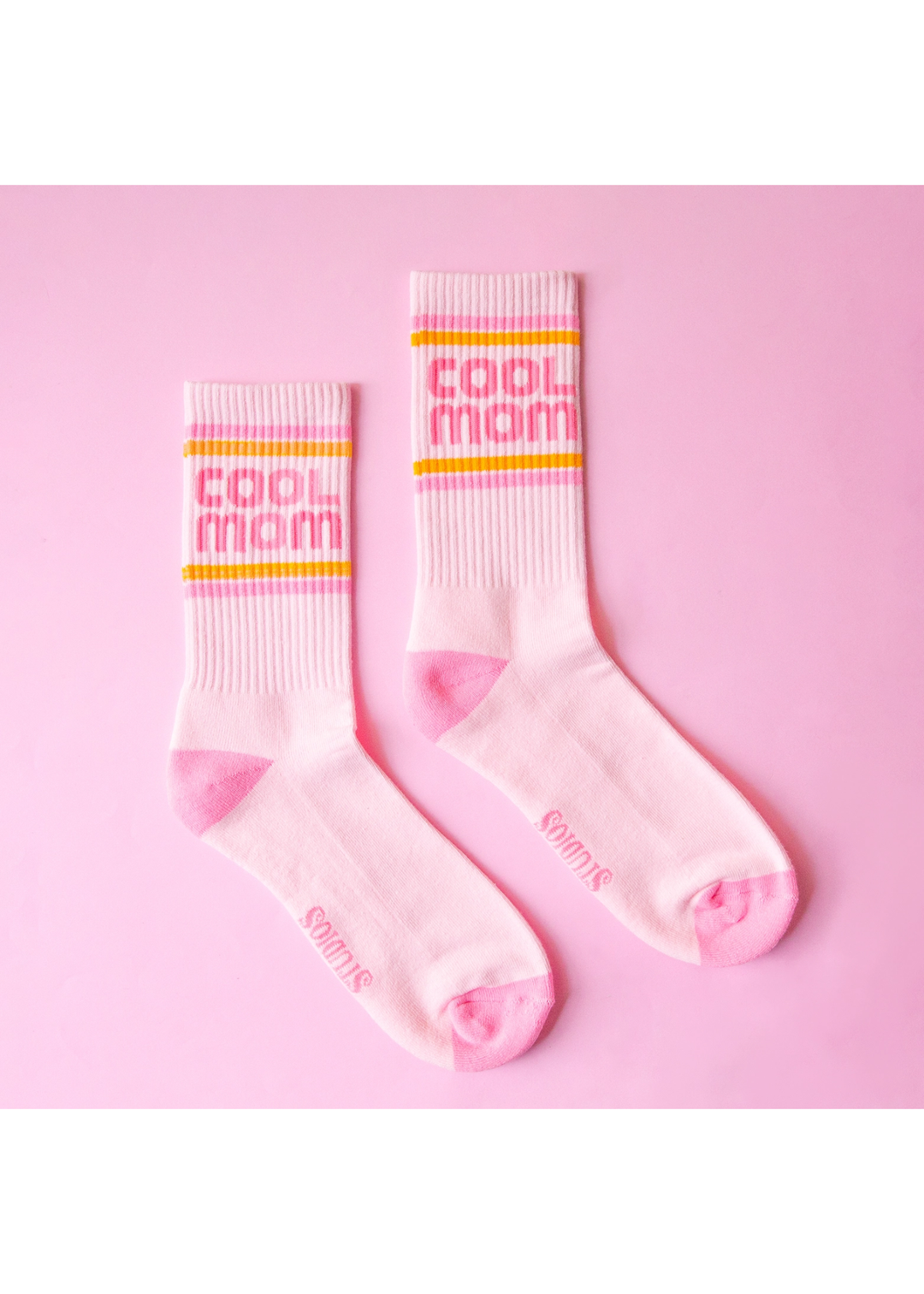 Light pink crew socks with a "Cool Mom" graphic and stripes against a pink background