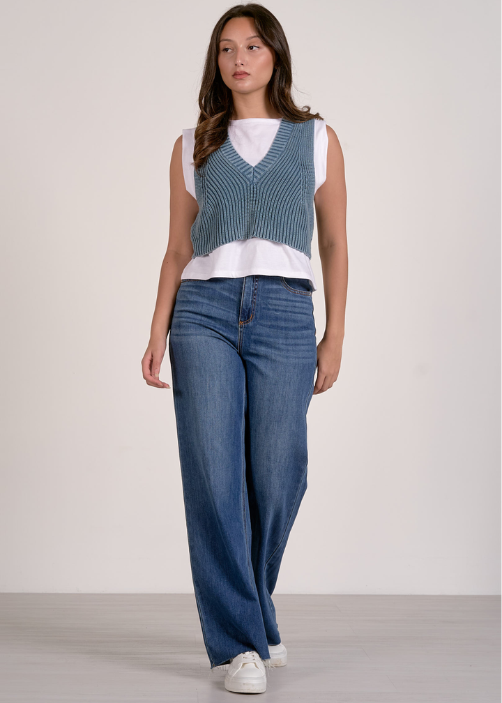 Woman wearing a blue and white layered top with jeans