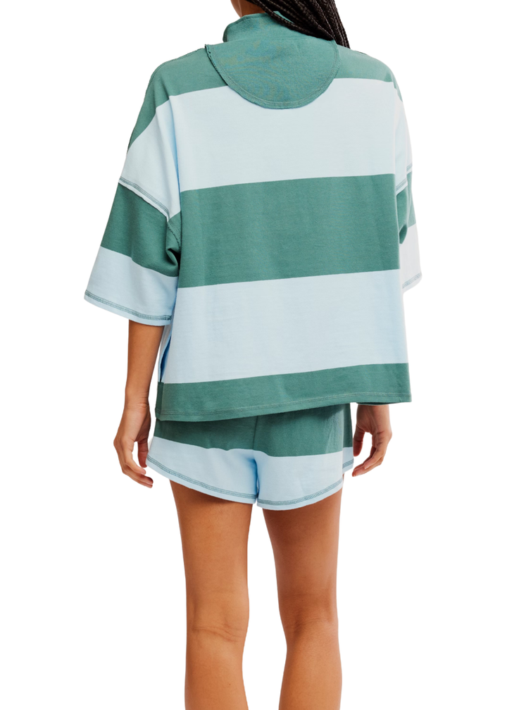 Woman turned around wearing a matching set with teal and blue stripes