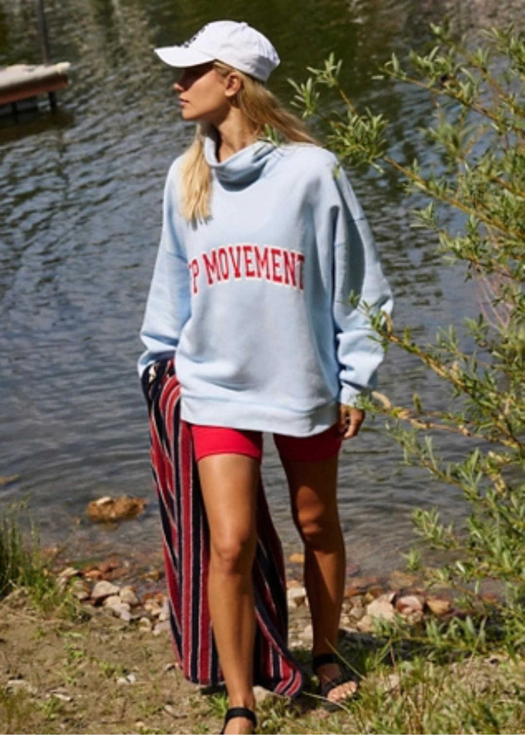 Woman wearing a blue sweatshirt with red lettering and red shorts