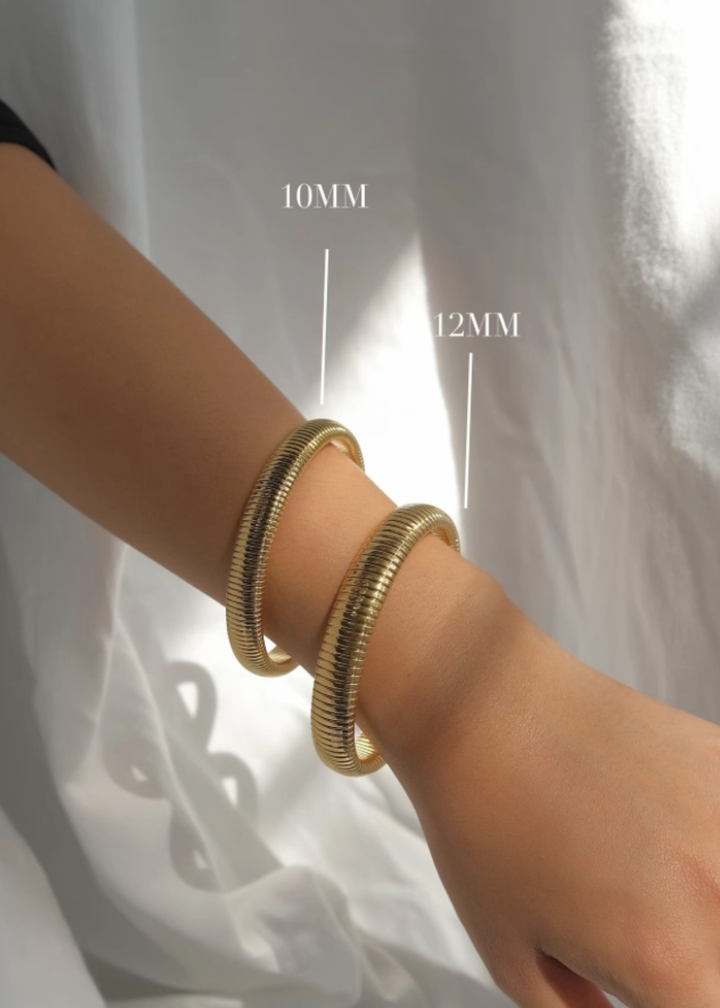 Woman wearing two gold bangle bracelets