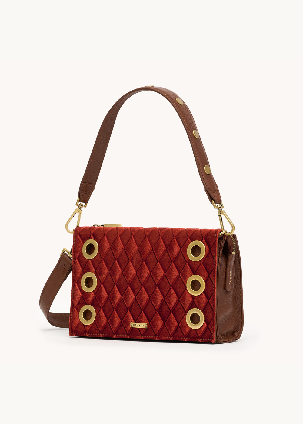 Red velvet handbag with gold and brown leather accents on a white background