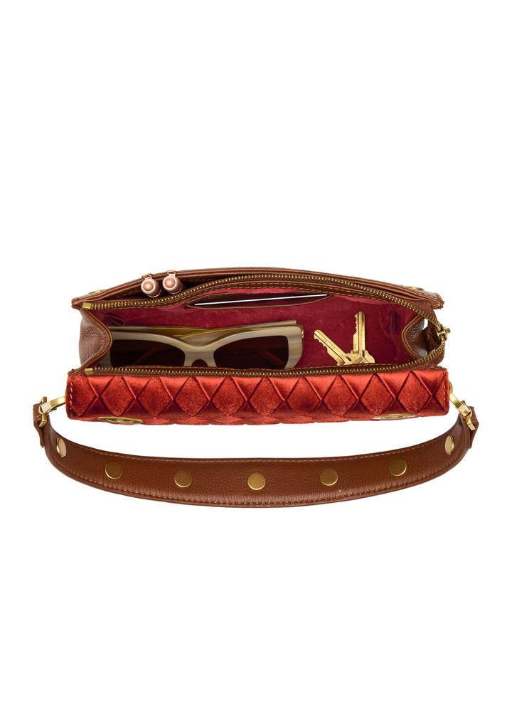 Red velvet and brown leather purse open on a white background