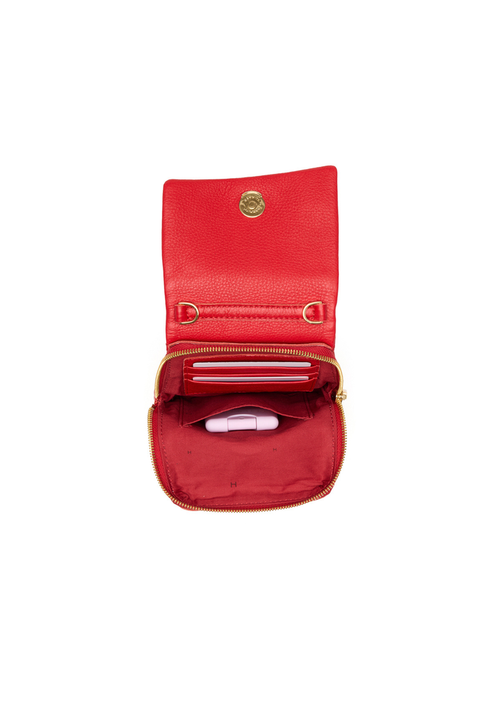 Red leather purse with gold accents sitting open on a white background
