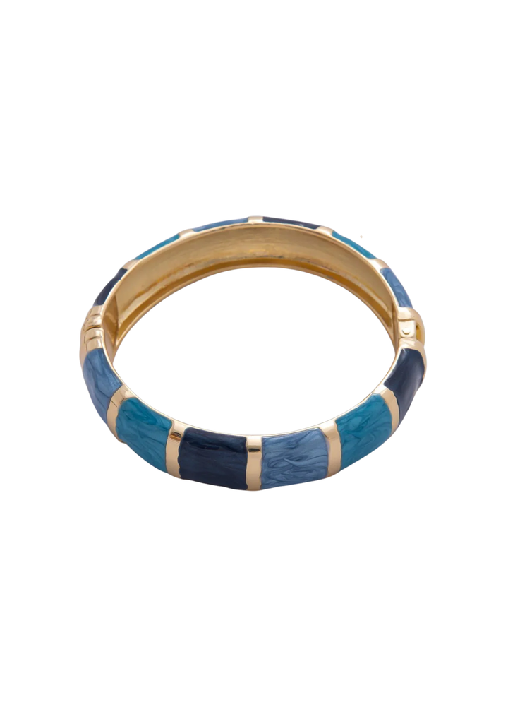 Gold framed bangle bracelet with blue enamel squares on a white background