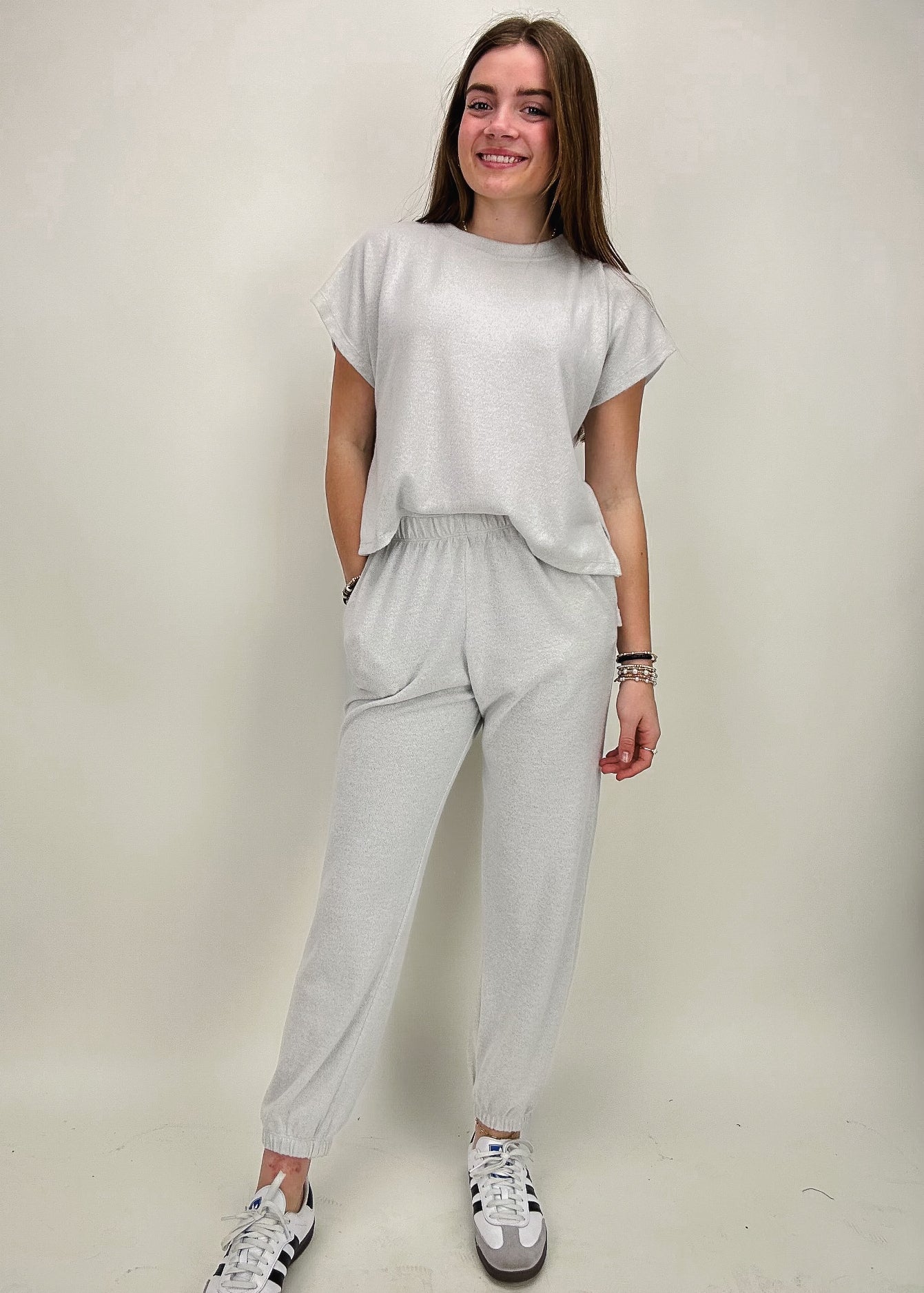 silver jumpsuit with short sleeves, joggers, and fitted waistline