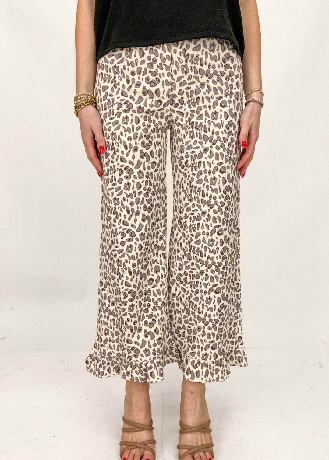Person wearing leopard print pants on a white background