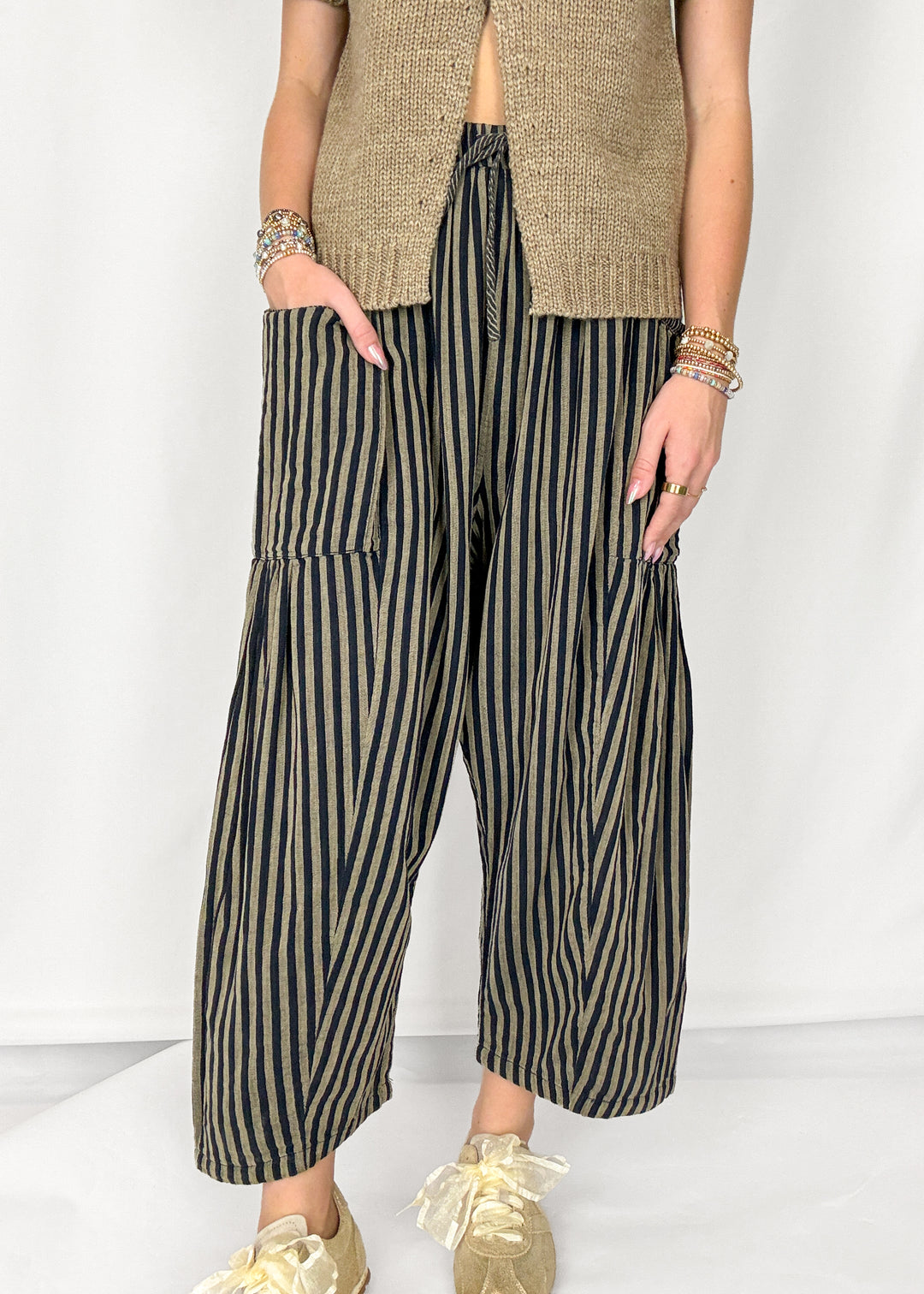 Woman wearing tan and navy striped harlem style pants