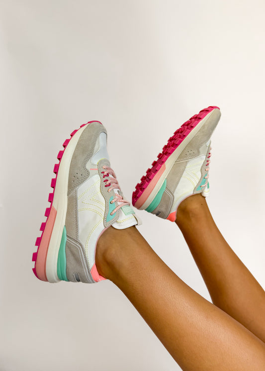 Colorful sneakers with pink soles on a neutral background