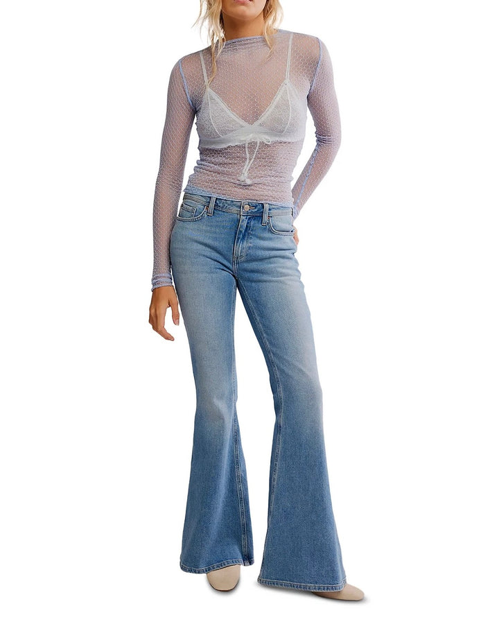 Woman wearing a sheer top and flared jeans 