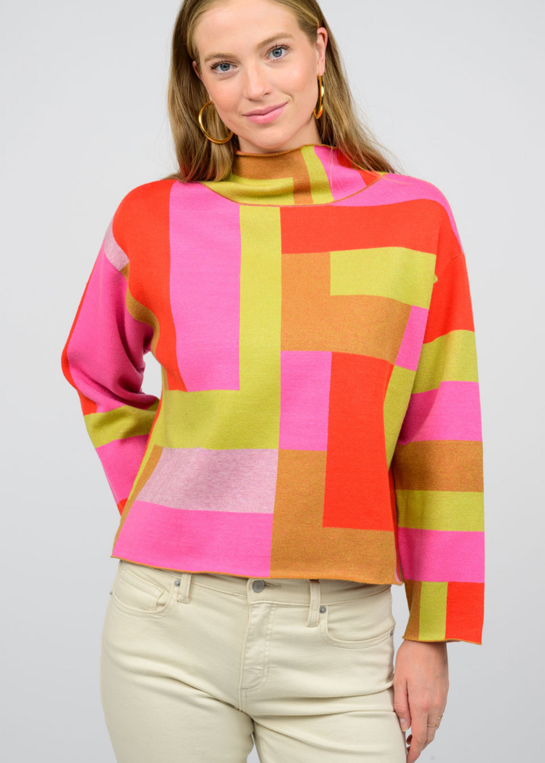 pink, green, and orange color block abstract print sweater with mock neckline and loose fit sleeves