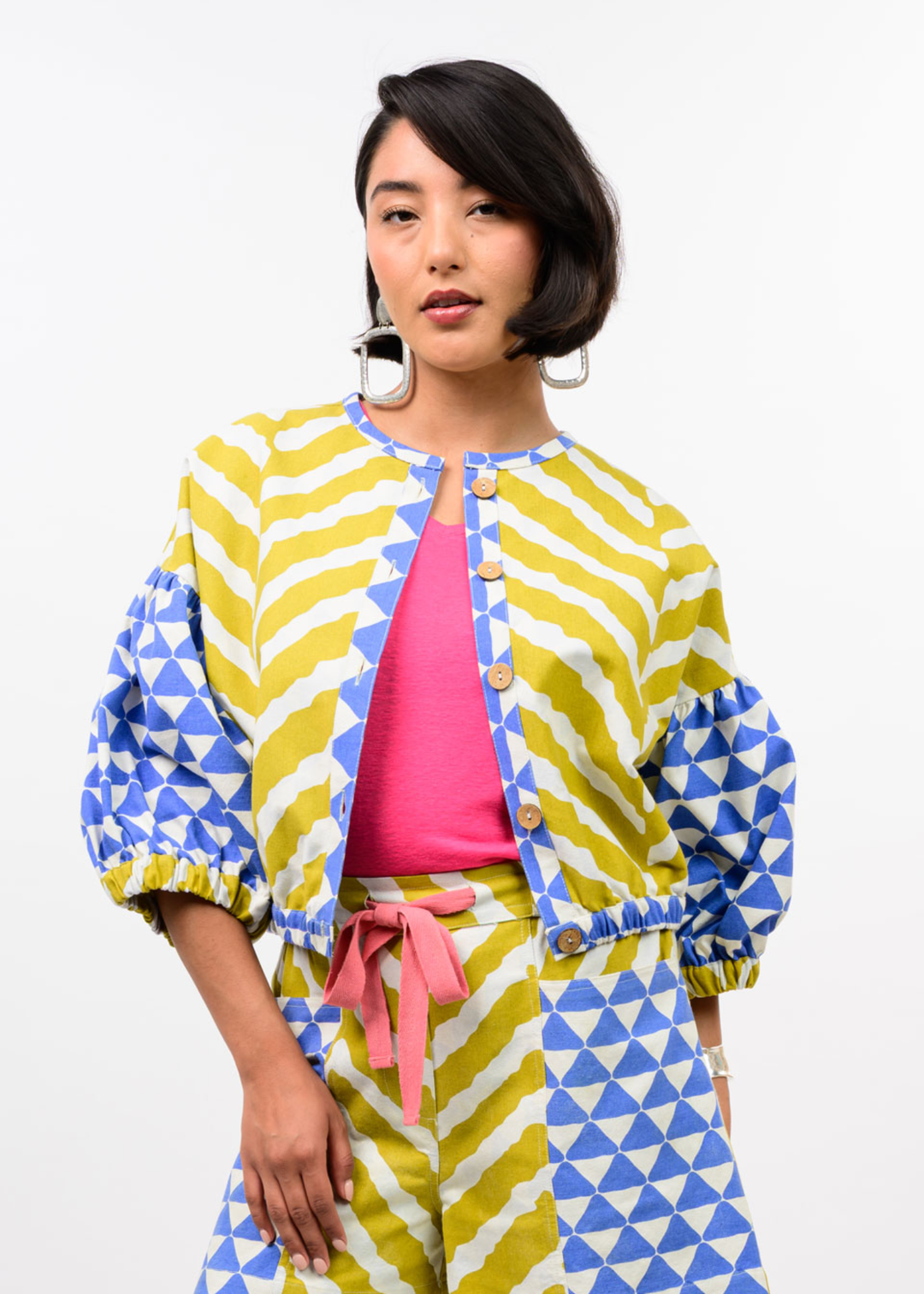 Woman wearing a yellow, blue, and white patterned cardigan with matching pants