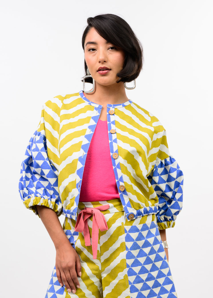 Woman wearing a yellow, blue, and white patterned cardigan with matching pants