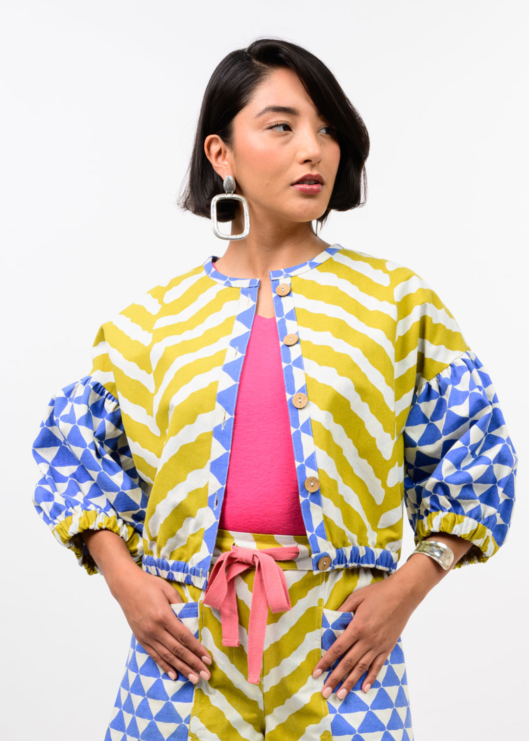 Woman wearing a yellow, blue, and white patterned cardigan with matching pants