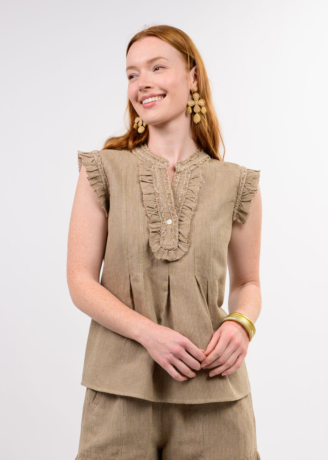 Woman wearing a brown top with ruffle details and matching pants