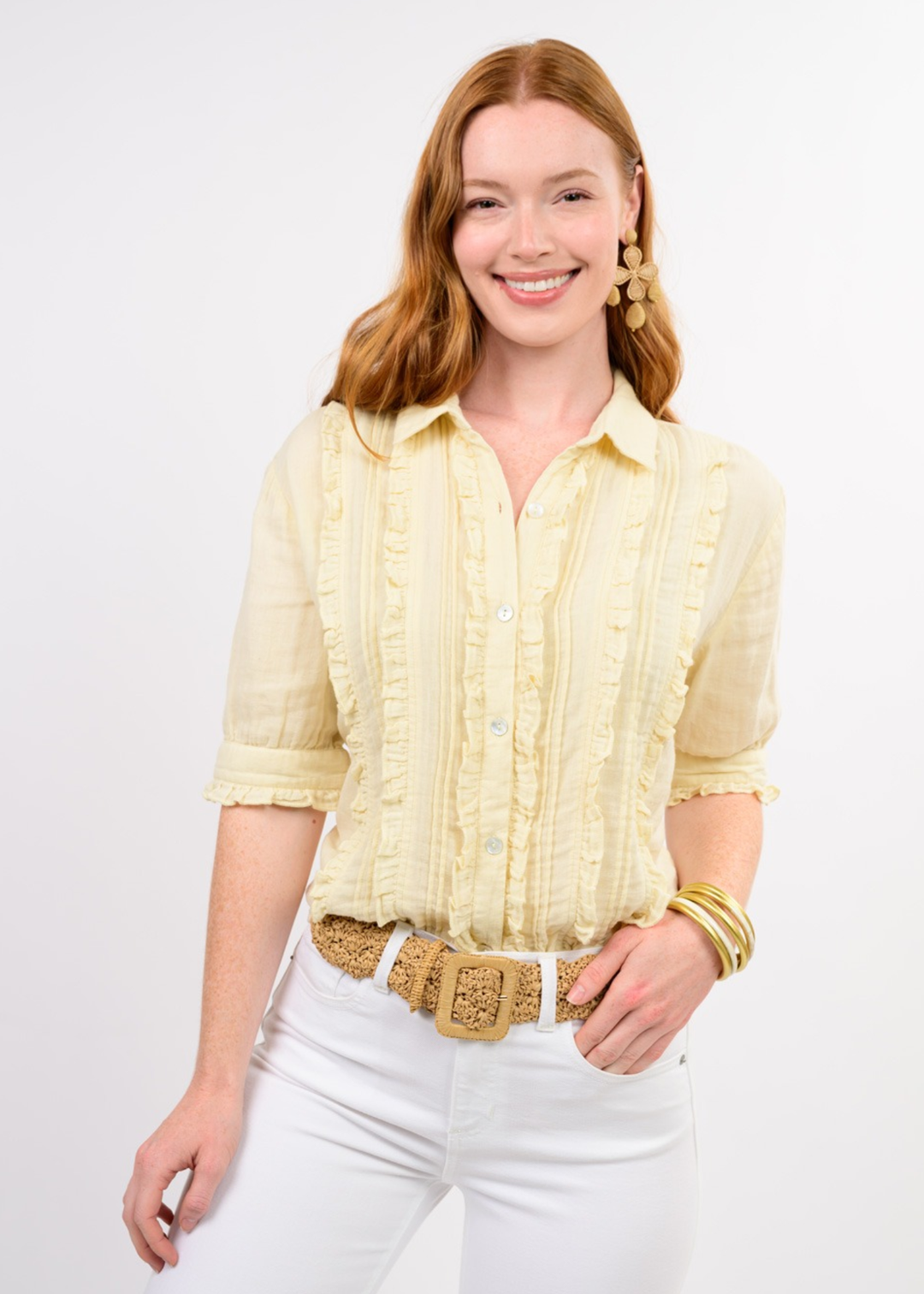 Woman wearing a yellow short sleeve button down with ruffle accents