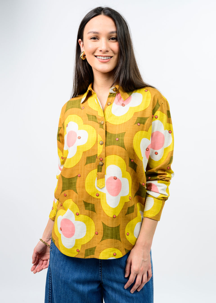 Woman in a multi colored, half button down floral top. 