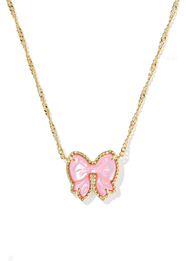 Women's gold necklace with a bow shaped pendant and a pink center stone