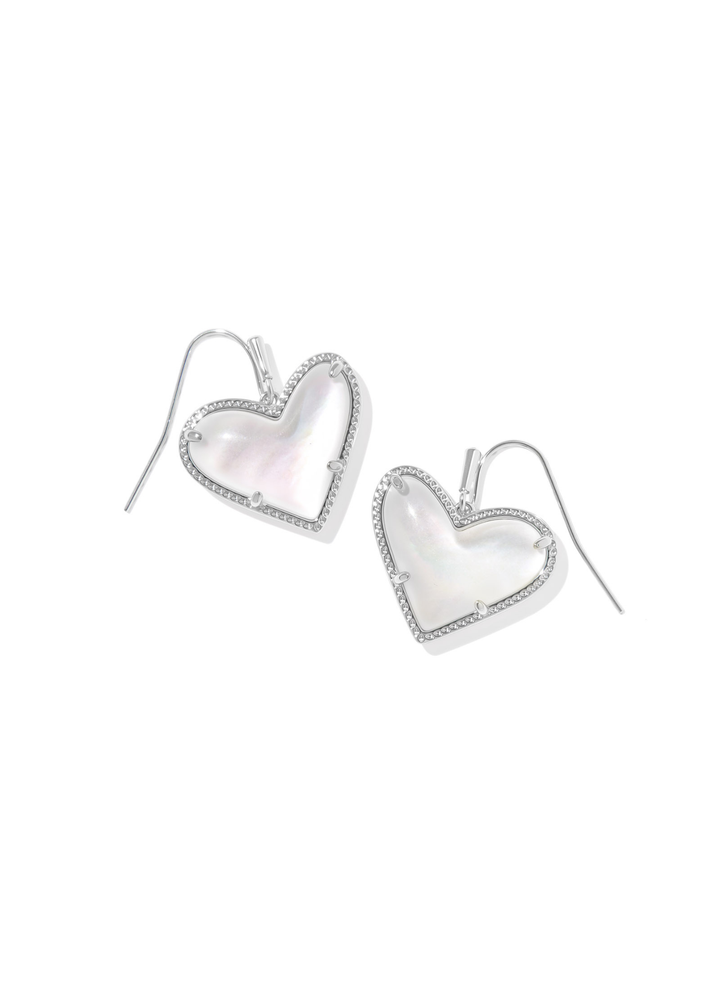 Silver framed heart shaped earrings with an ivory stone on a white background