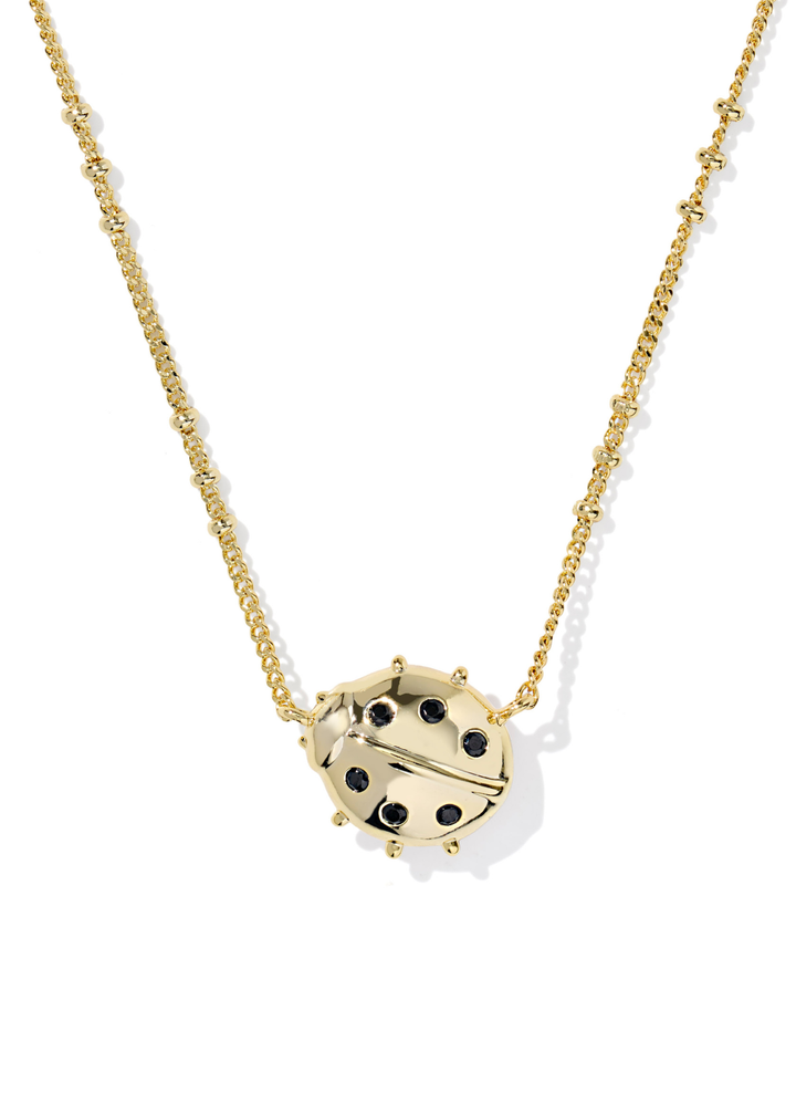 Gold necklace with a gold and black ladybug pendant on a white background