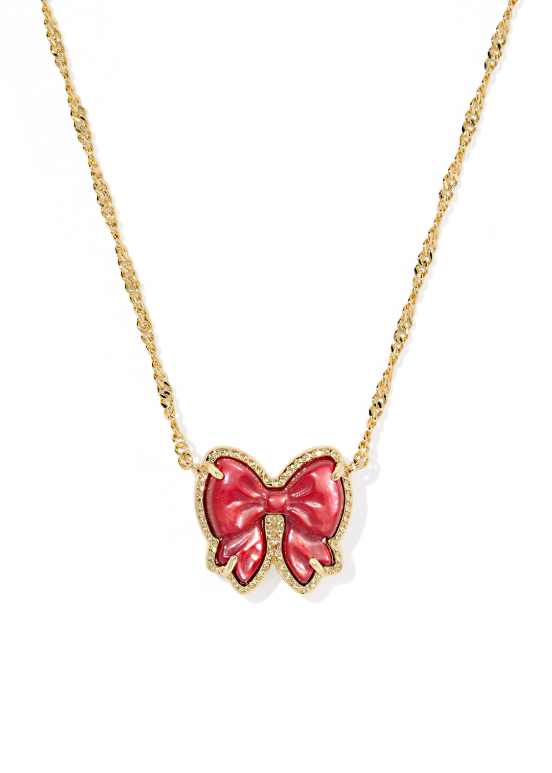 Gold necklace with a red bow pendant on a white background