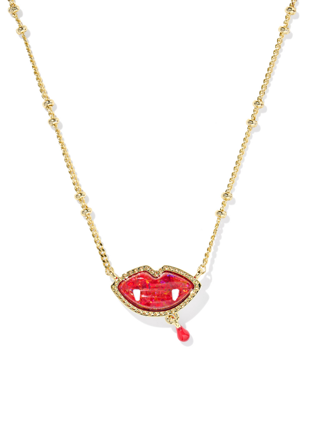 Gold necklace with a red vampire lips pendant on a white necklace