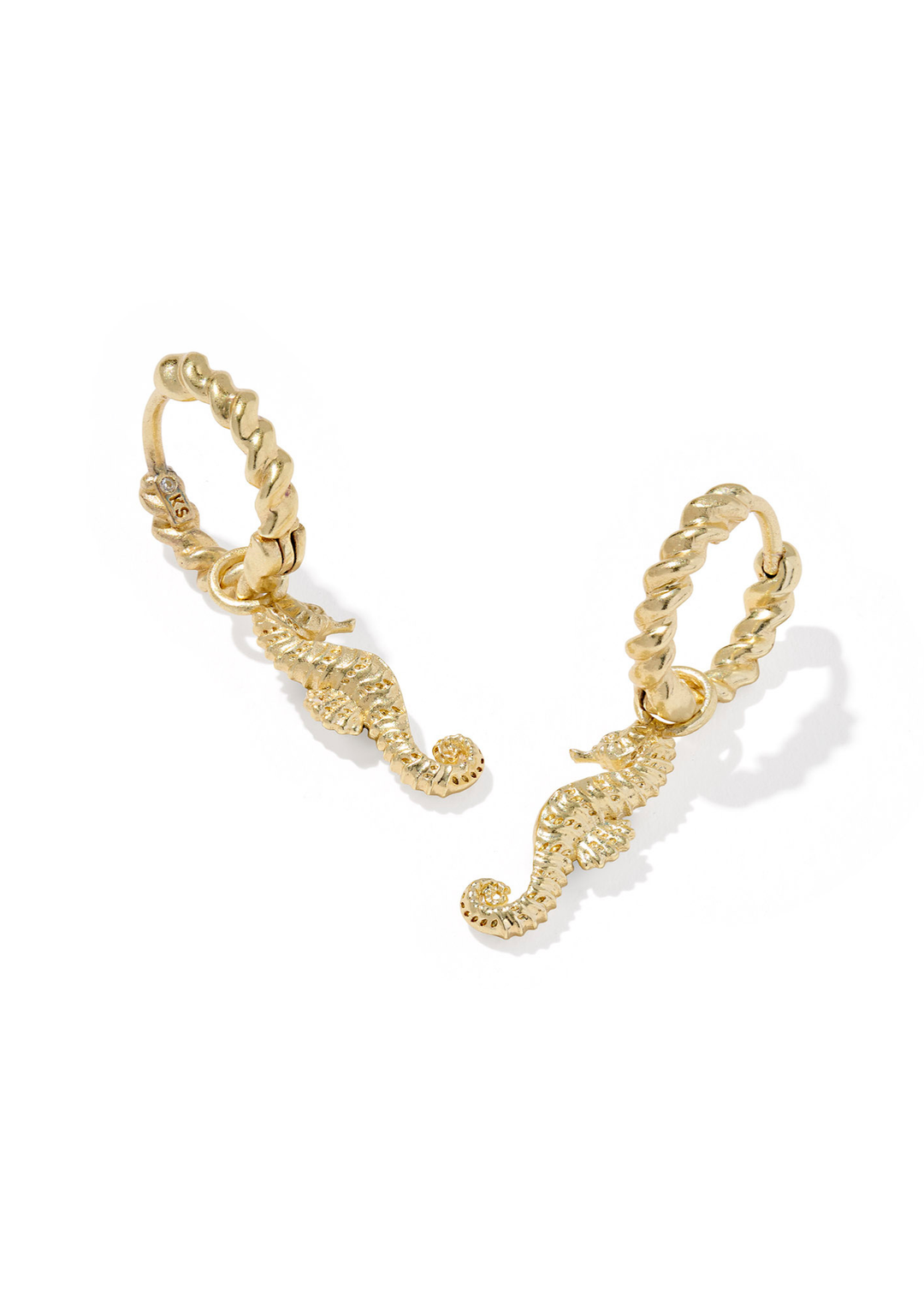 Gold seahorse shaped huggie earrings on a white background