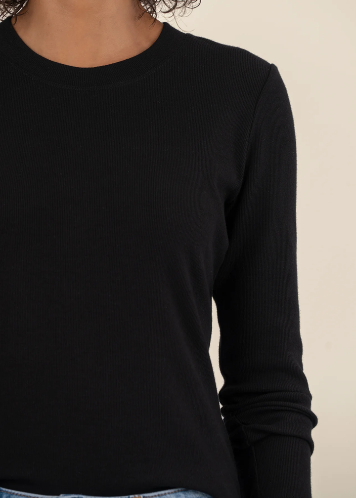 Close up of a woman wearing a black long sleeve tee